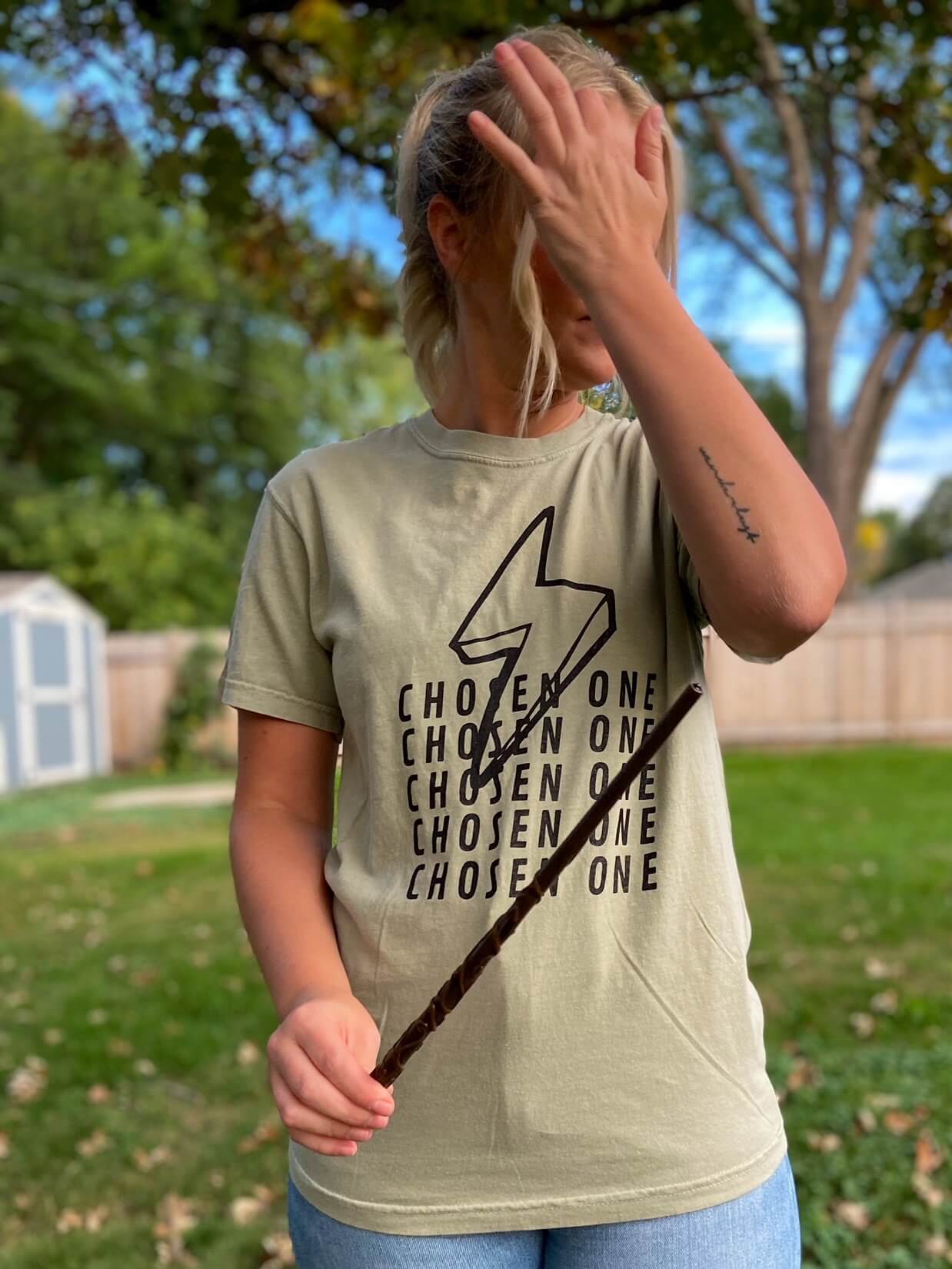 sage green tshirt that repeats the words "Chosen One" vertically with a lightning bolt overlapping.