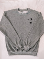 Load image into Gallery viewer, Charcoal Gray sweatshirt with 3 black embroidered stars on the left chest. 
