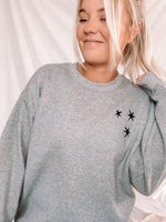 Load image into Gallery viewer, Charcoal Gray sweatshirt with 3 black embroidered stars on the left chest.
